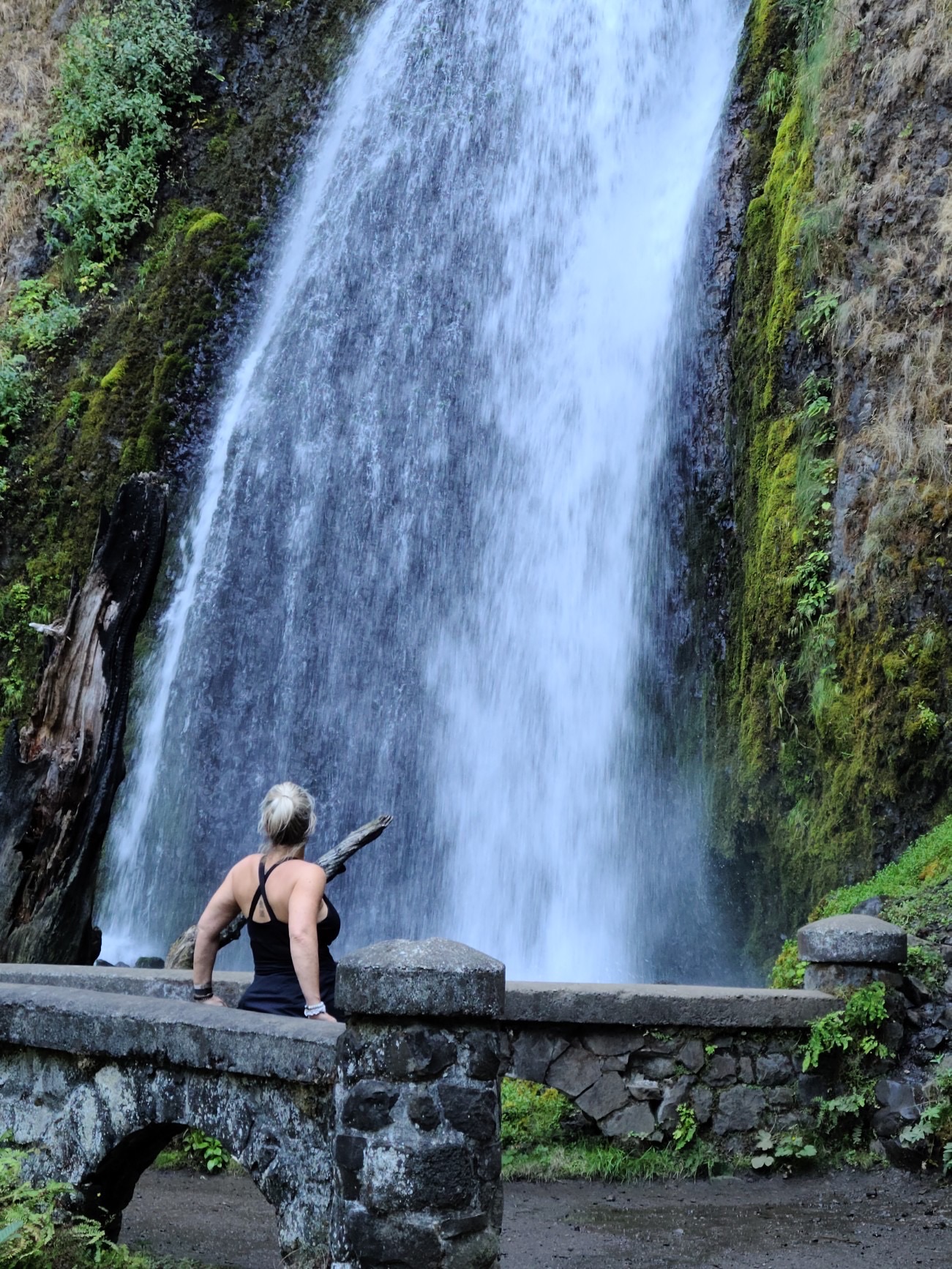 Tamey Greene looking up at a waterfall